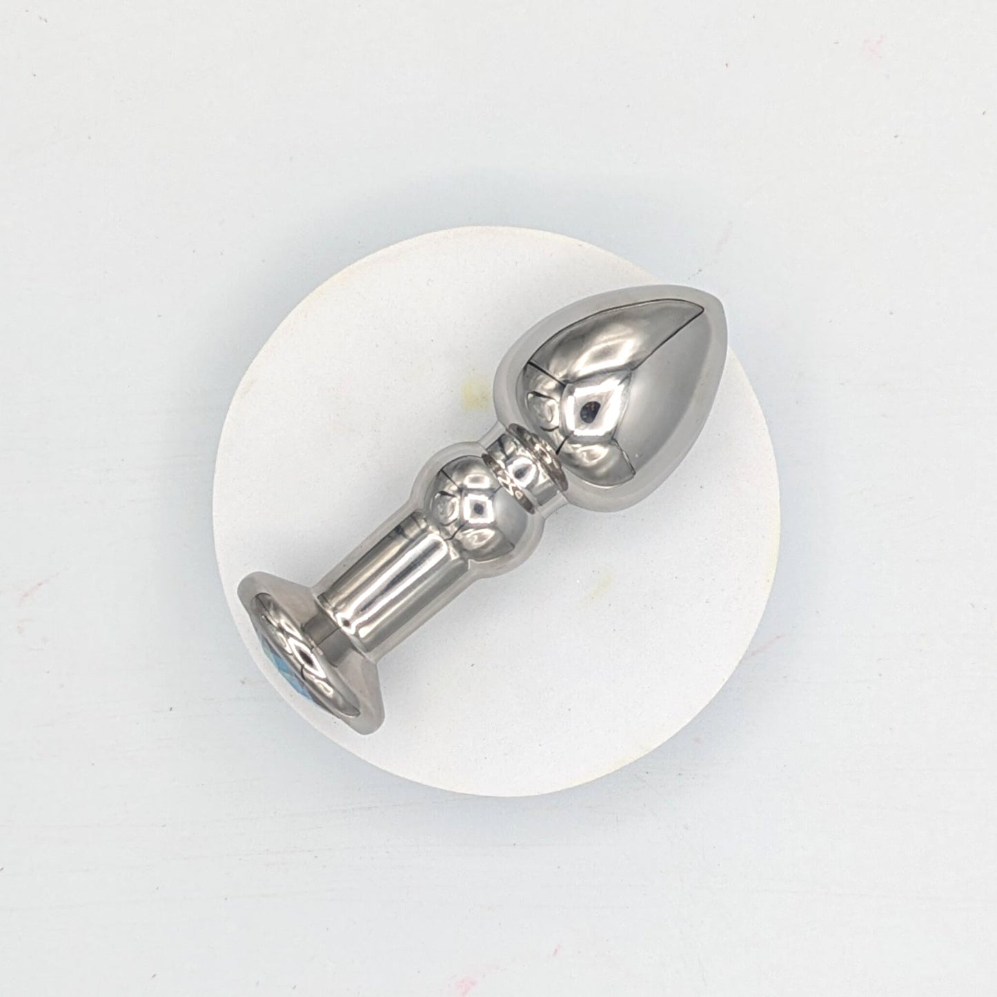 Tapón anal con joyas de acero inoxidable y cuerpo redondeado.